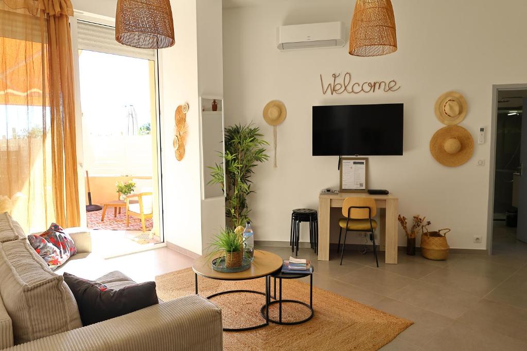 un salon avec un canapé et une télévision dans l'établissement Très bel appartement avec piscine en bord de mer, à Ajaccio
