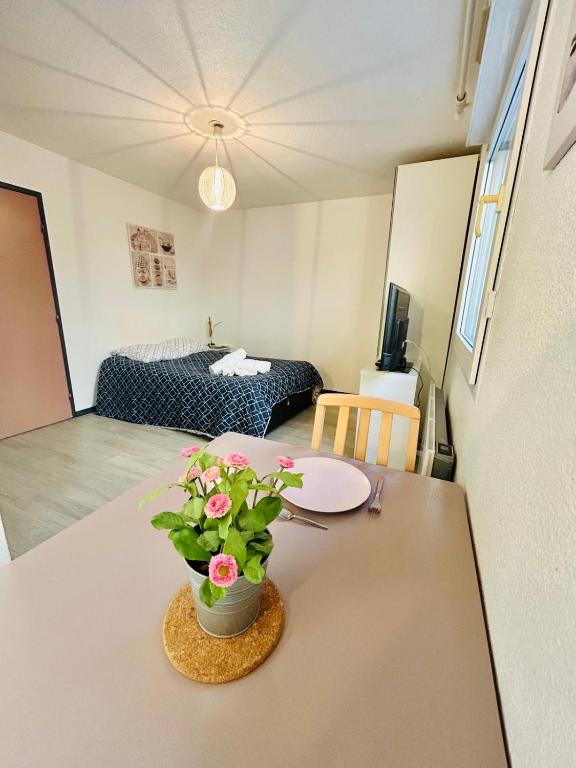 une pièce avec une table avec un vase de fleurs dessus dans l'établissement Studio Thermotel 208, à Saint-Martin-dʼUriage