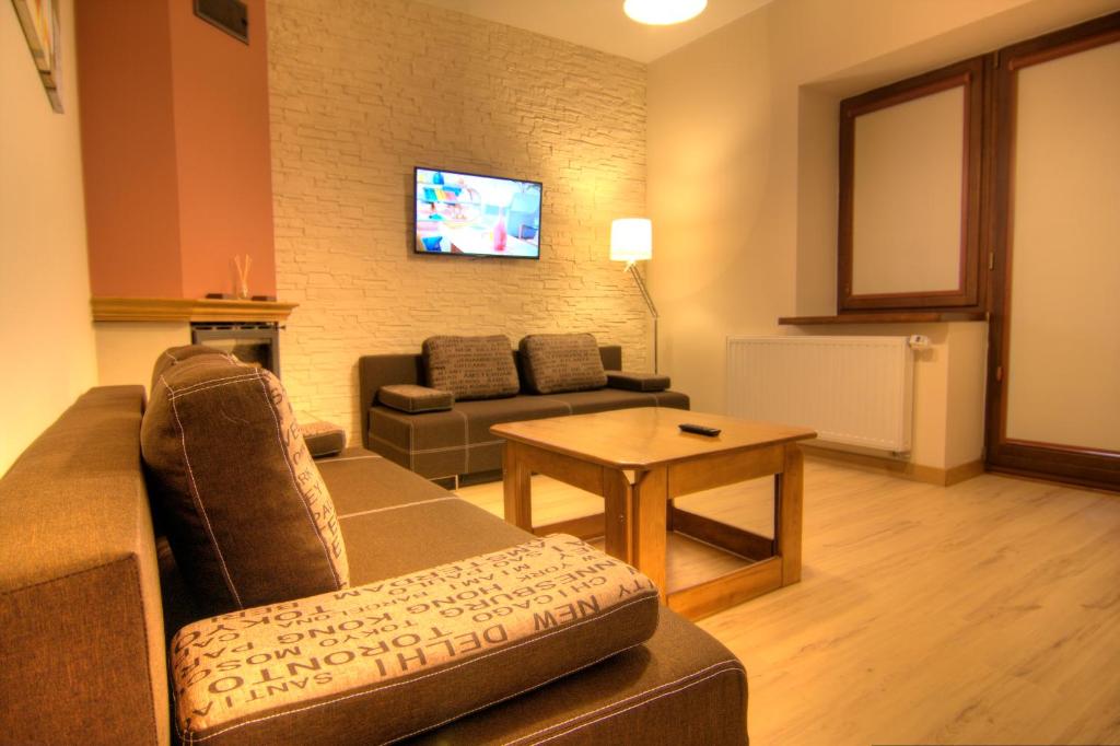 a living room with a couch and a table at Apartament Bielany Kraków in Kraków