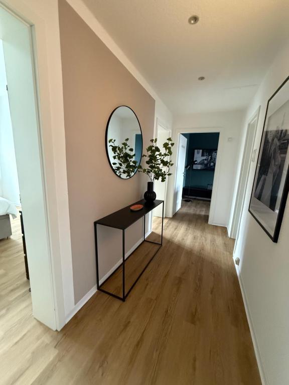 einen Flur mit einem Tisch und einem Spiegel in der Unterkunft Apartment 3 Eilenriede in Hannover