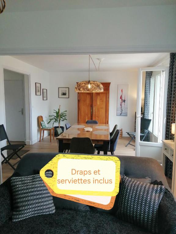 - un salon avec une table et un panneau jaune dans l'établissement Appartement aux Portes de St Goustan, à Auray