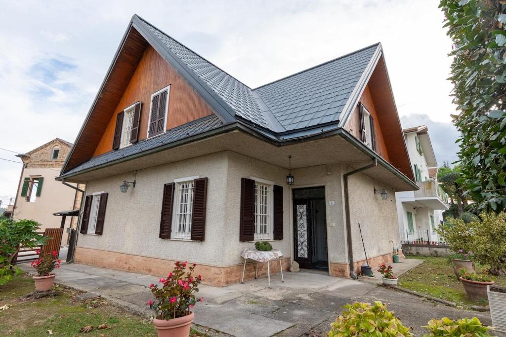 a small white house with a black roof at Mare & Monti scopri le Marche in Stazione Falerone