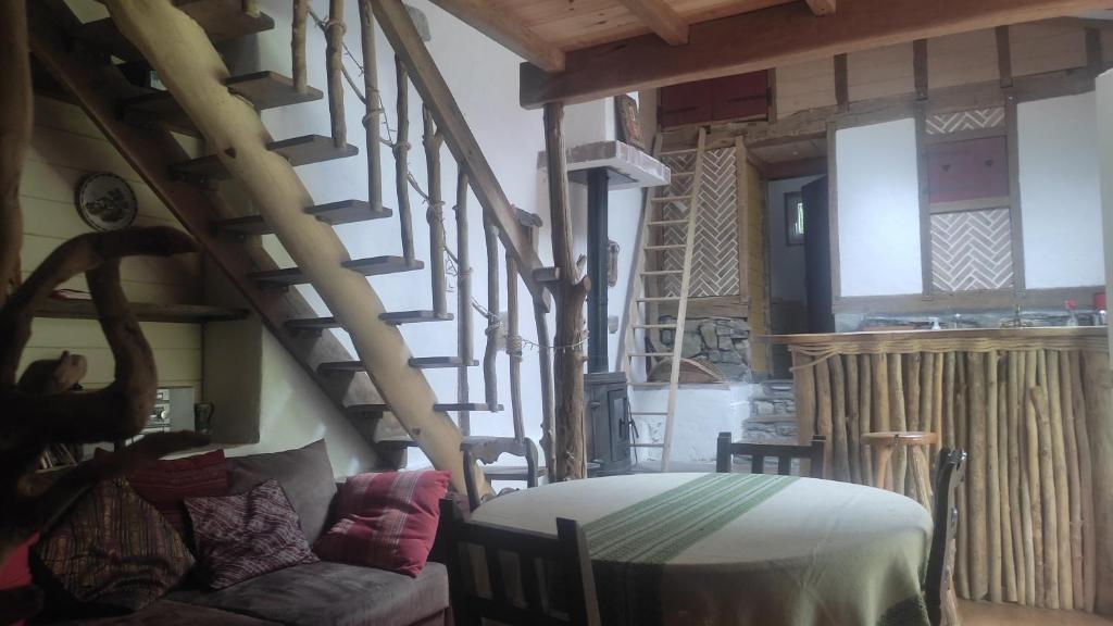 a living room with a spiral staircase and a couch at amets politak in Hasparren