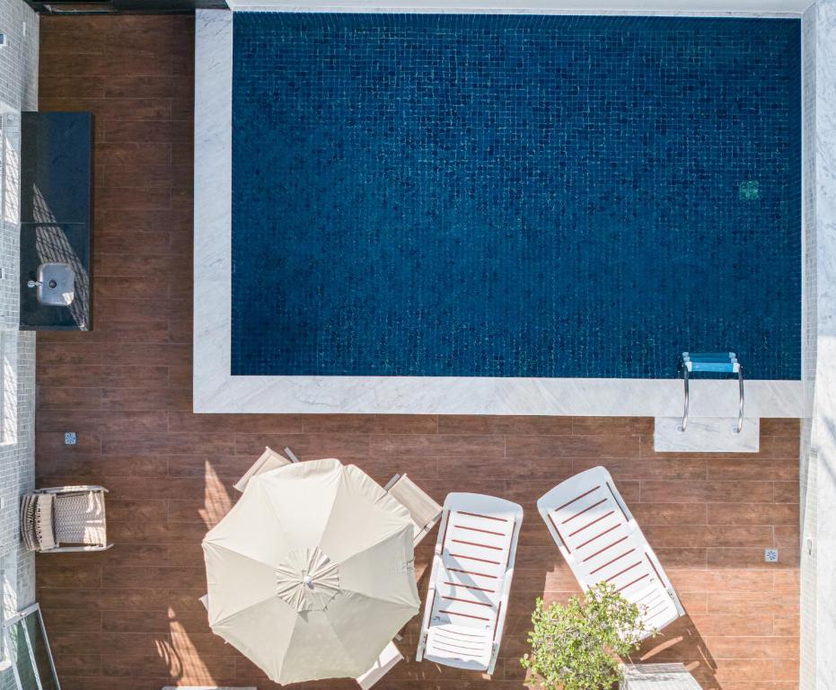una vista aérea de una piscina con sillas y sombrilla en Luxury Penthouse with private Pool, en Recife