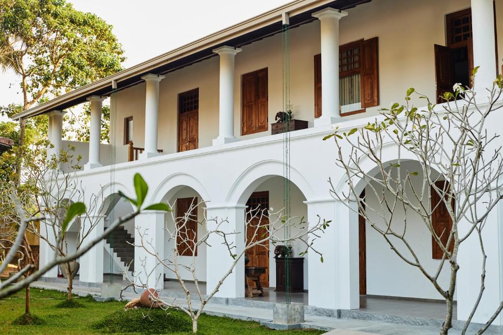 una vista exterior de un edificio blanco con columnas en Villa White Queen Resort &amp; Spa, en Galle
