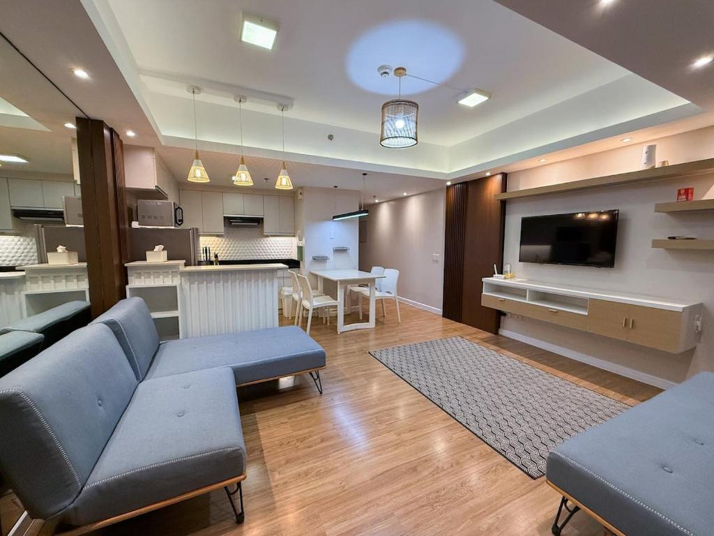 a large living room with a couch and a tv at Modern 1BR Unit in Abreeza Place T2 with Pay Parking in Davao City