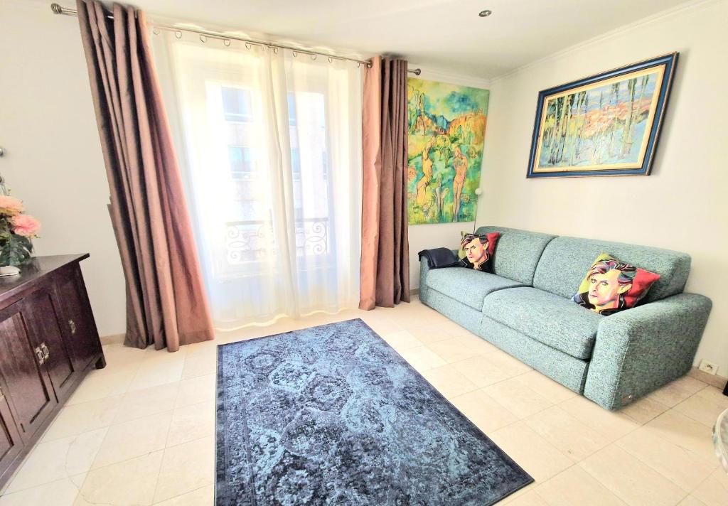 un salon avec un canapé bleu et une fenêtre dans l'établissement Paris Arc de Triomphe- Tour Eiffel - Champs Élysées - 4 people, à Paris