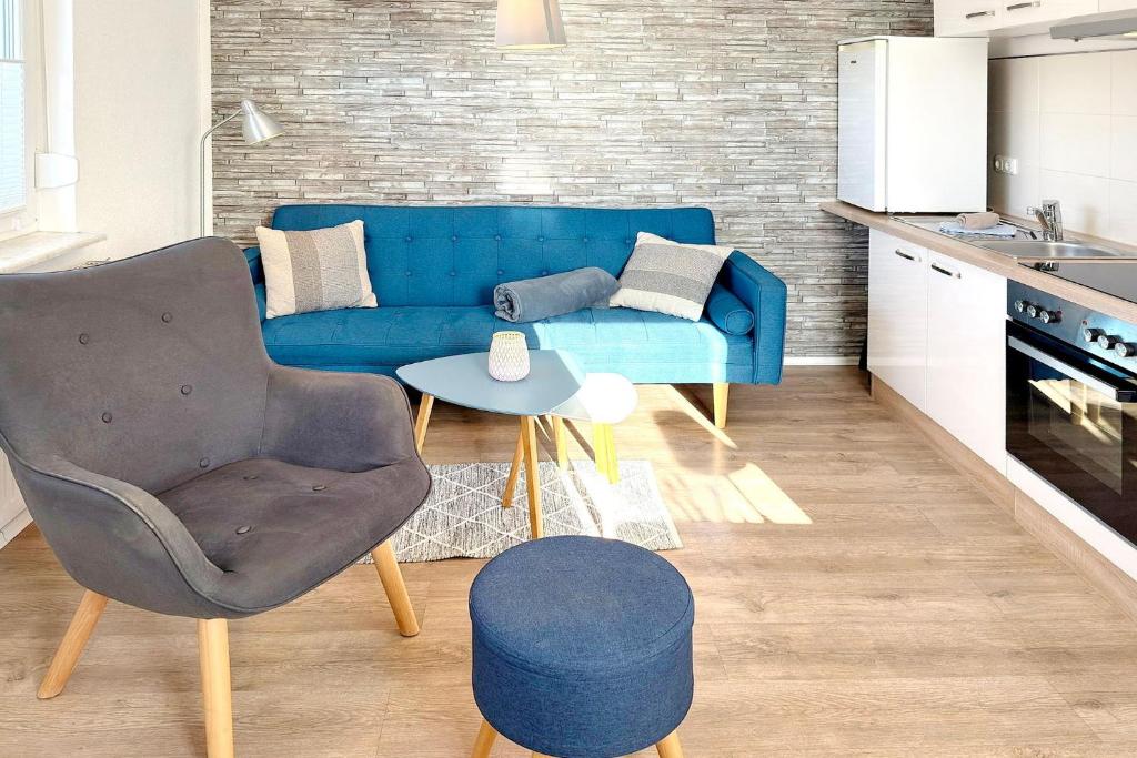 Una sala de estar con un sofá azul y una mesa. en Ferienwohnung Kamske, en Lübbenau