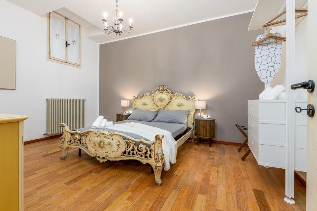 a bedroom with a king sized bed and wooden floors at BeRGAMO ALTA - Piazza Mercato del Fieno HOUSE in Bergamo