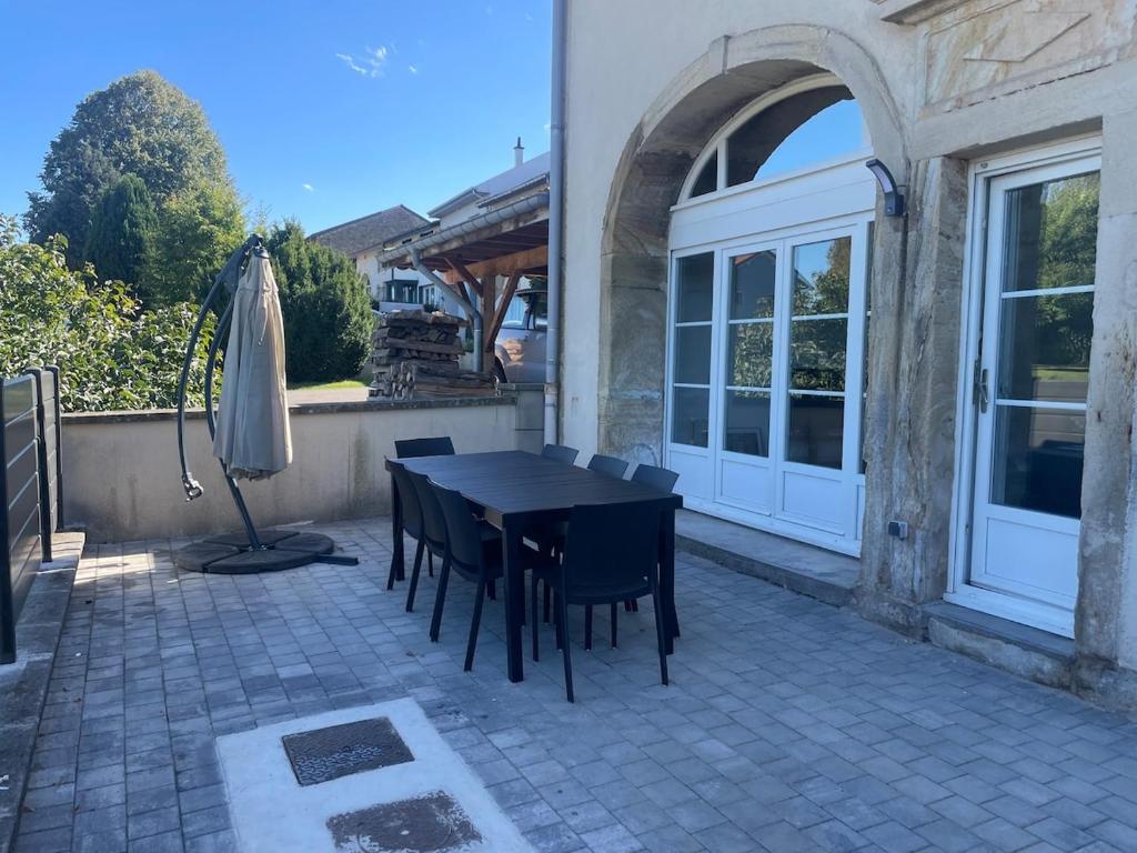 a patio with a table and chairs and an umbrella at Chez Paul in Jeuxey