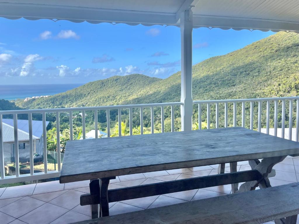 a picnic table on a porch with a view of the ocean at Villa martinique in Sainte-Luce