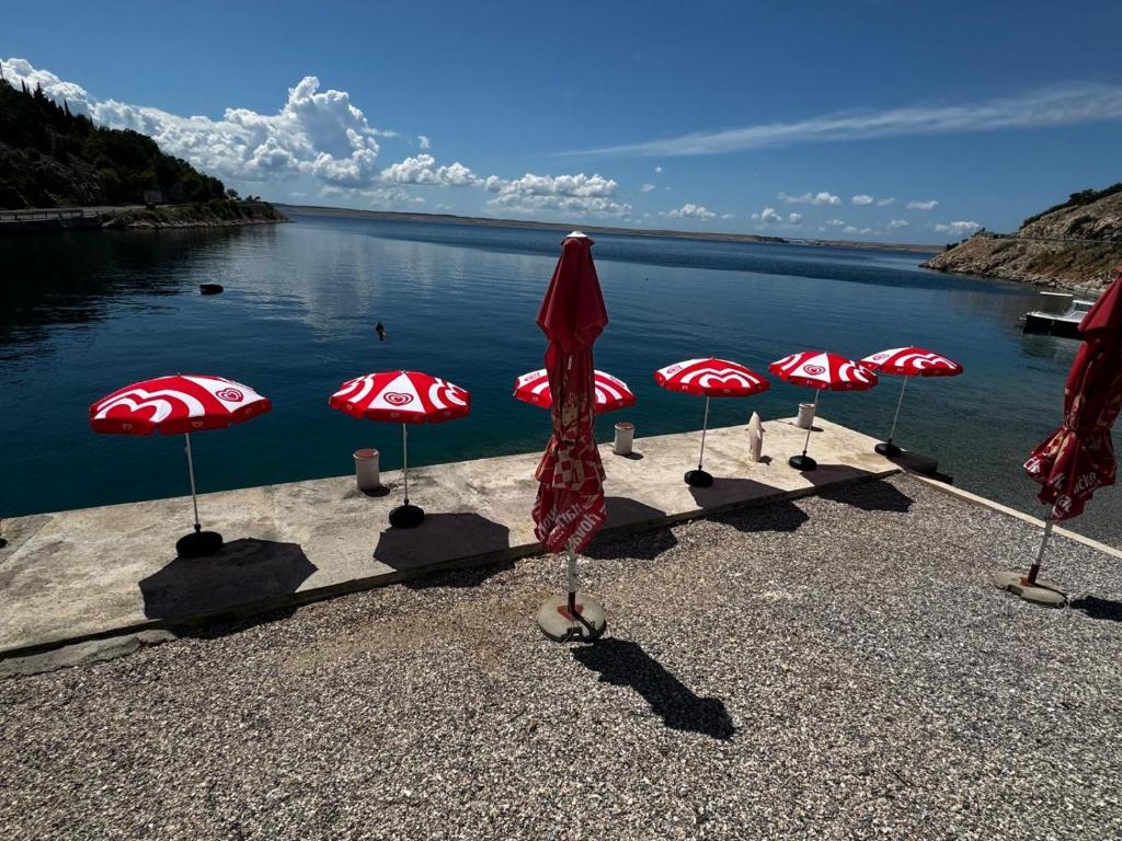 a group of red and white umbrellas on the water at Apartment Tribanj Florida in Viniština