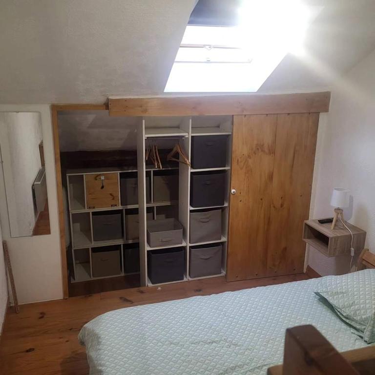 - une chambre avec un lit et un placard en bois dans l'établissement Appartement montagne, à Saint-Bonnet-en-Champsaur