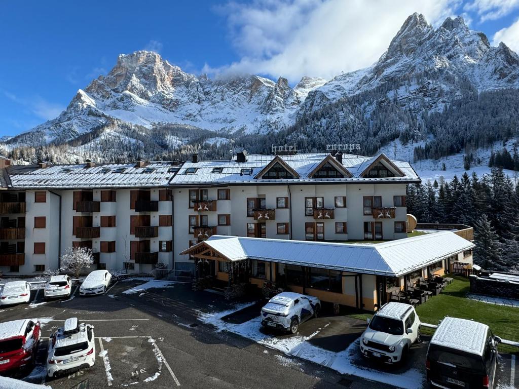 a hotel with a snow covered mountain in the background at Hotel Europa in San Martino di Castrozza