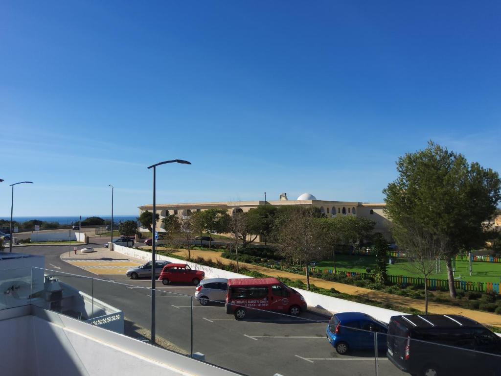 a parking lot with cars parked in front of a building at Lorarno in Praia do Carvoeiro