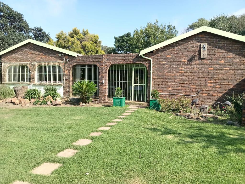 a brick building with a grass yard with a pathway at Green Haven in Benoni