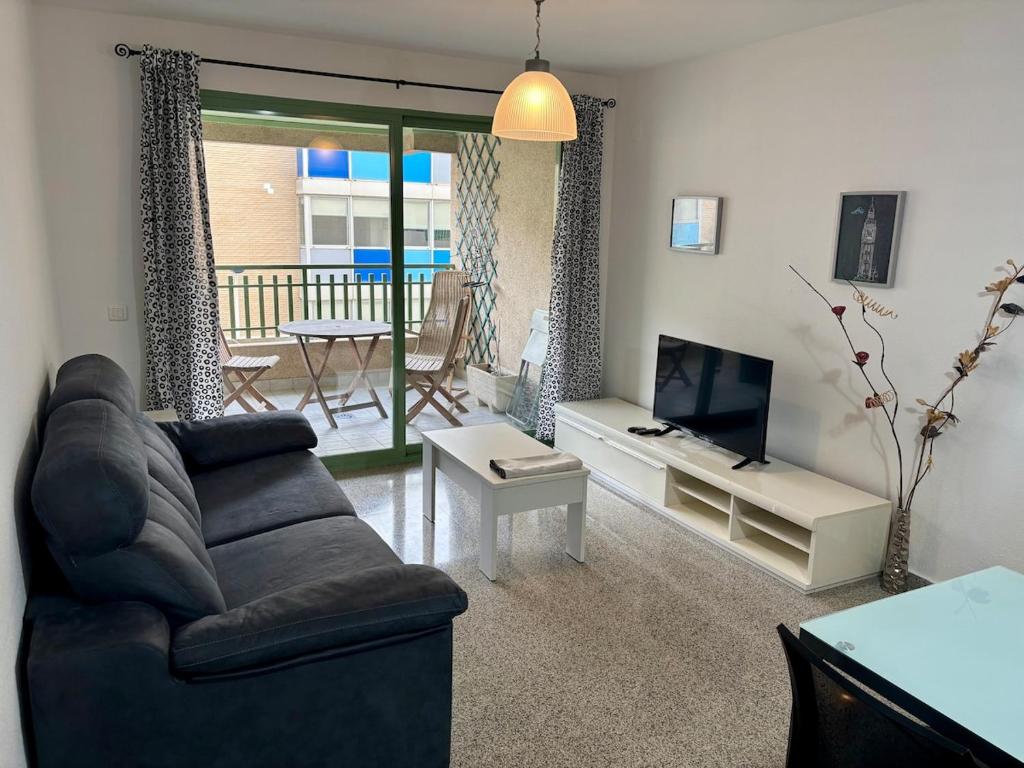 a living room with a couch and a television at Exclusive flat in Patacona Beach in Valencia