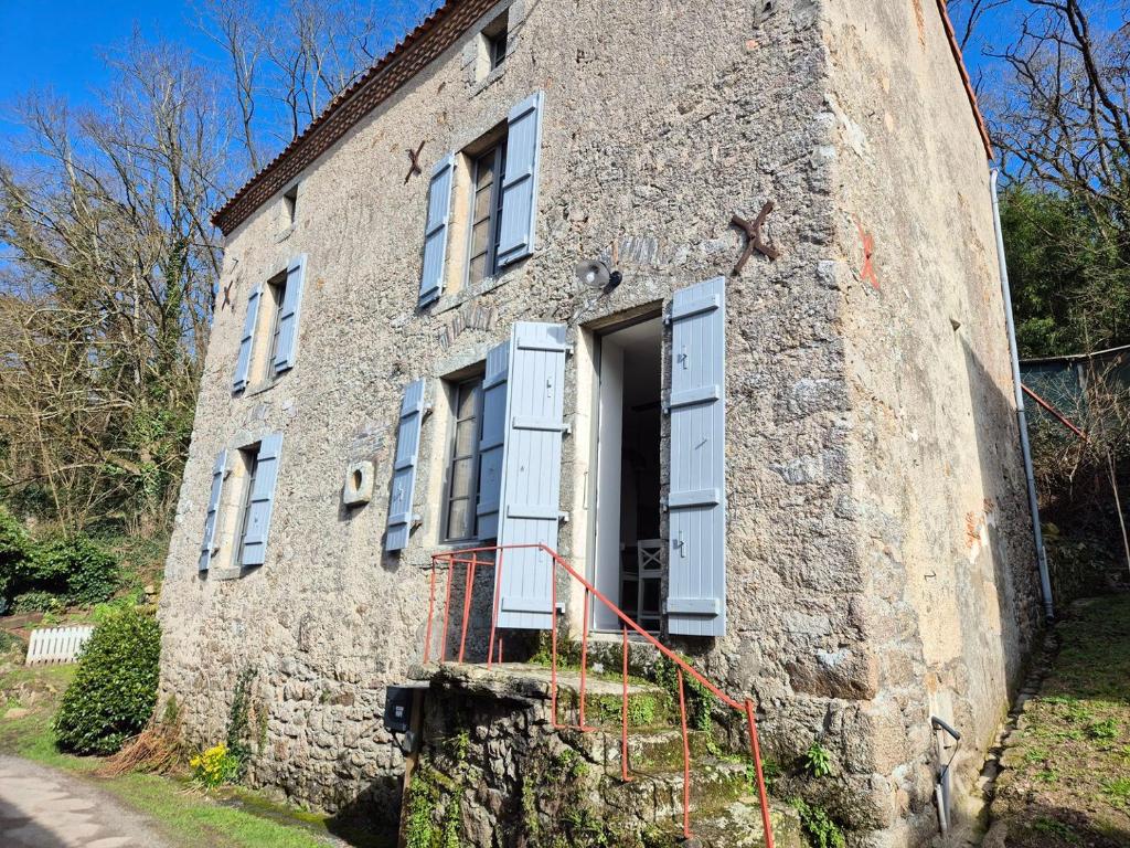 un ancien bâtiment en pierre avec une porte ouverte dans l'établissement La maison de Pierre, studio à 20 min du Puy du Fou, à Mortagne-sur-Sèvre