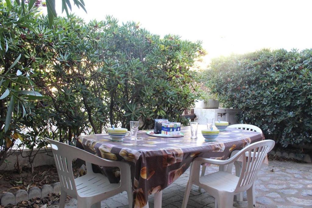 - une table avec deux chaises et une table avec de la vaisselle dans l'établissement Maison 4 pièces 8 couchages PORT LA NOUVELLE PN000-001, à Port-la-Nouvelle