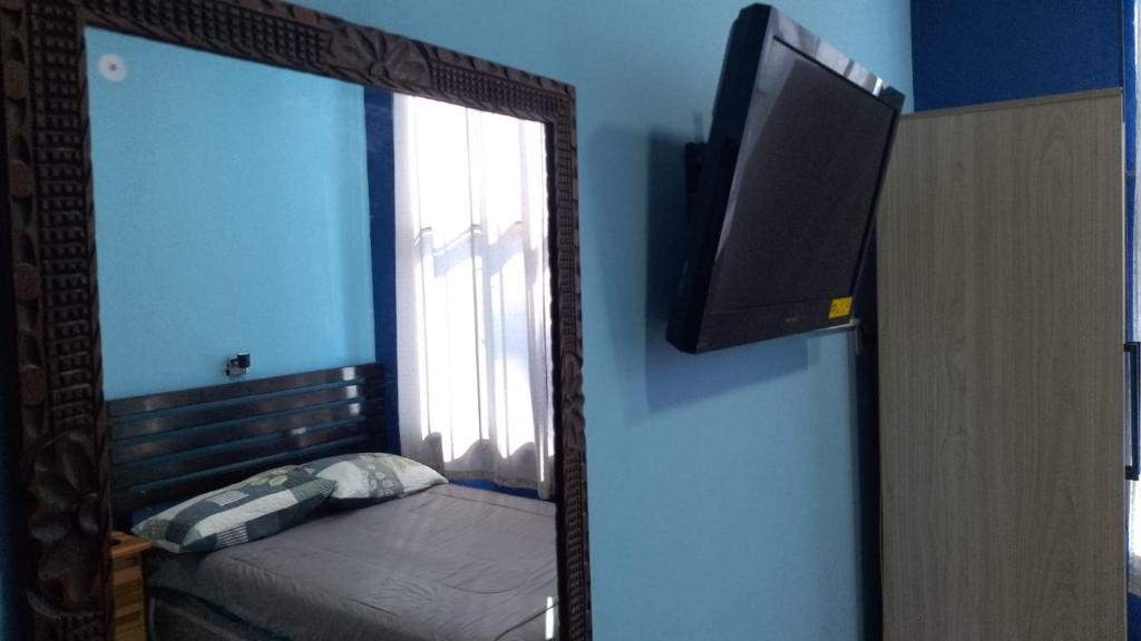 a mirror in a room with a bed and a window at Comfort Home Escalón in San Salvador