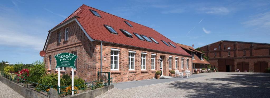 ein großes Backsteingebäude mit rotem Dach in der Unterkunft Rose in Fehmarn