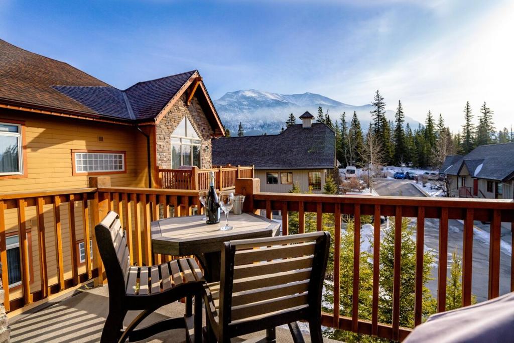 una terrazza con tavolo e sedie su una casa di The Raven Suite at Stoneridge Mountain Resort a Canmore