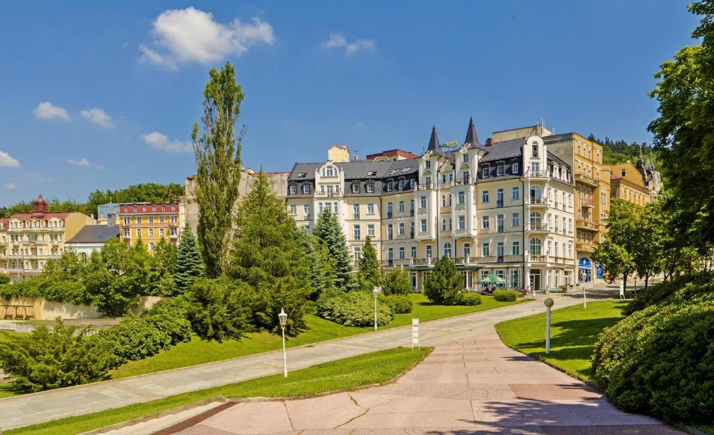 duży budynek z ścieżką przed nim w obiekcie Sun Palace Wellness Hotel w Mariańskich Łaźniach