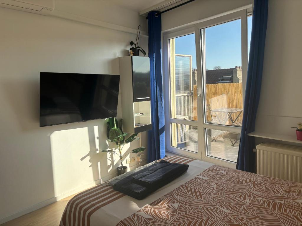 a bedroom with a bed and a large window at Bright studio close to everything! in Brussels