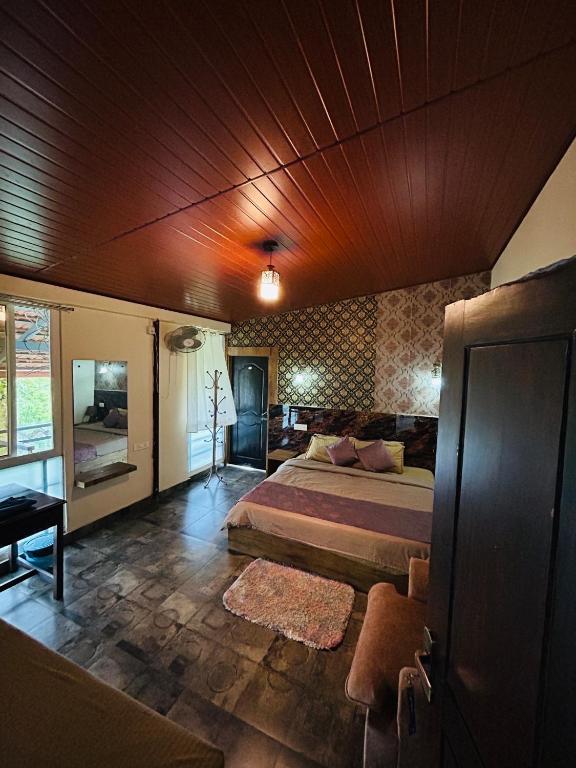 um quarto com uma cama grande e um tecto de madeira em Coorg Sana Riverside em Suntikoppa