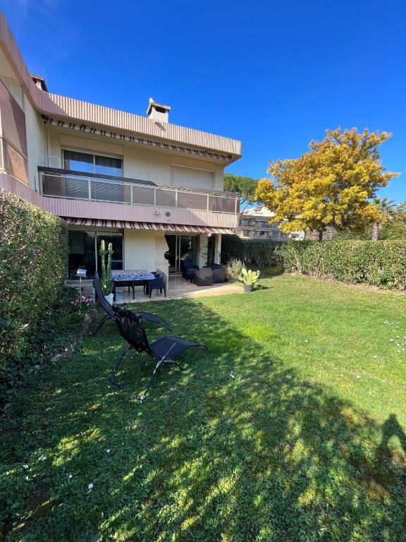 une maison avec un banc dans la cour dans l'établissement Villa Marina Cottage, à Mandelieu-la-Napoule