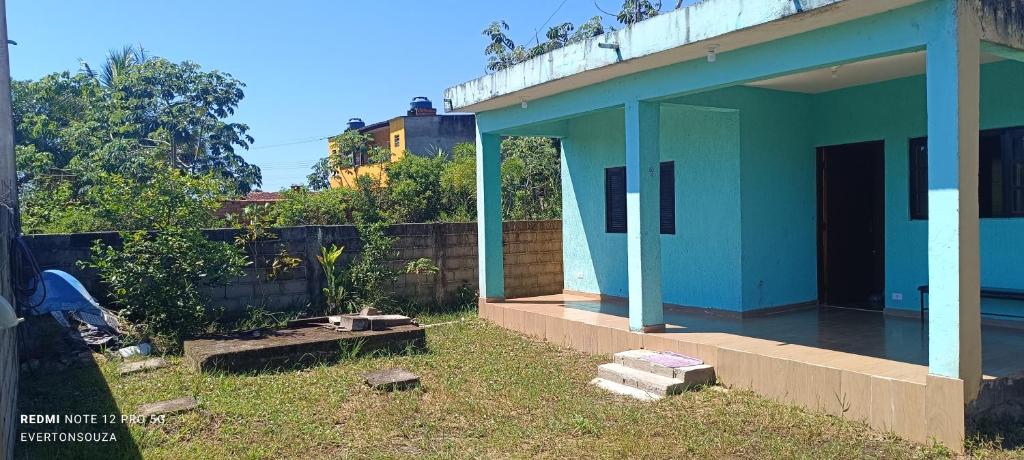 a blue house in a yard next to a fence at Casa Soul de Verão in Ilha Comprida