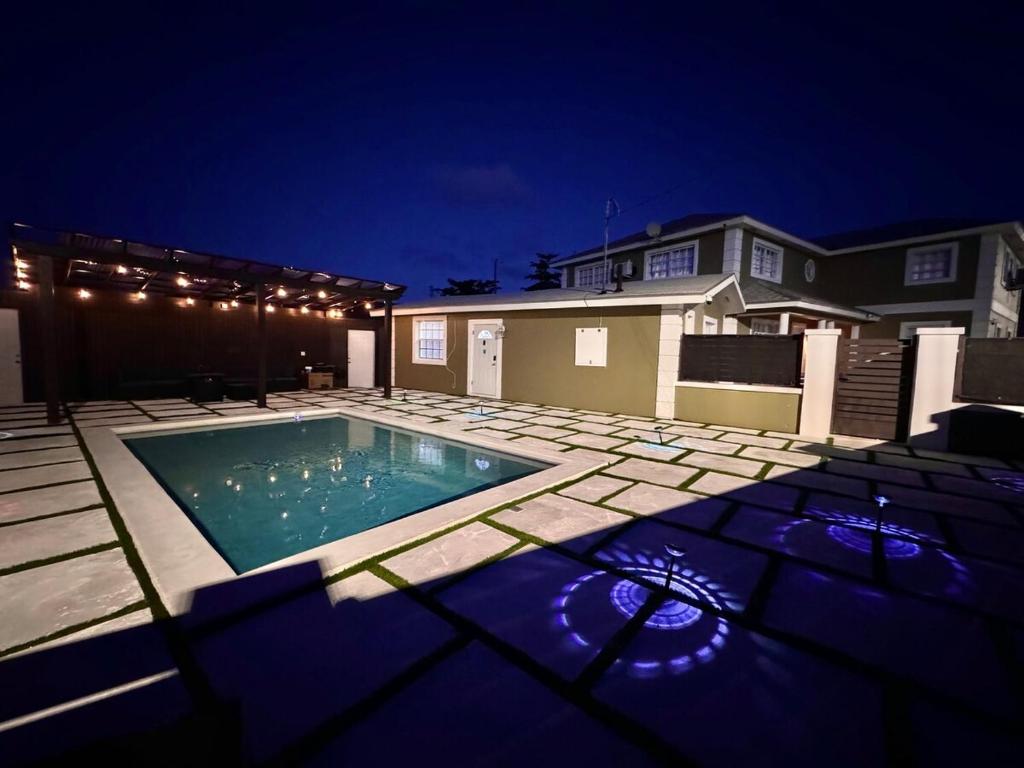 ein Swimmingpool vor einem Haus bei Nacht in der Unterkunft Island Haven 5BR Home with Pool Cottage in Nassau