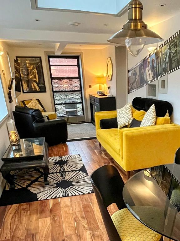 a living room with a yellow couch and chairs at New Forest Fordingbridge - Art Deco Unique Apartment in Fordingbridge