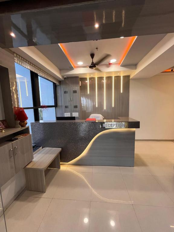 a kitchen with a counter with a bench and a table at hotel r k VILLA in Ahmedabad