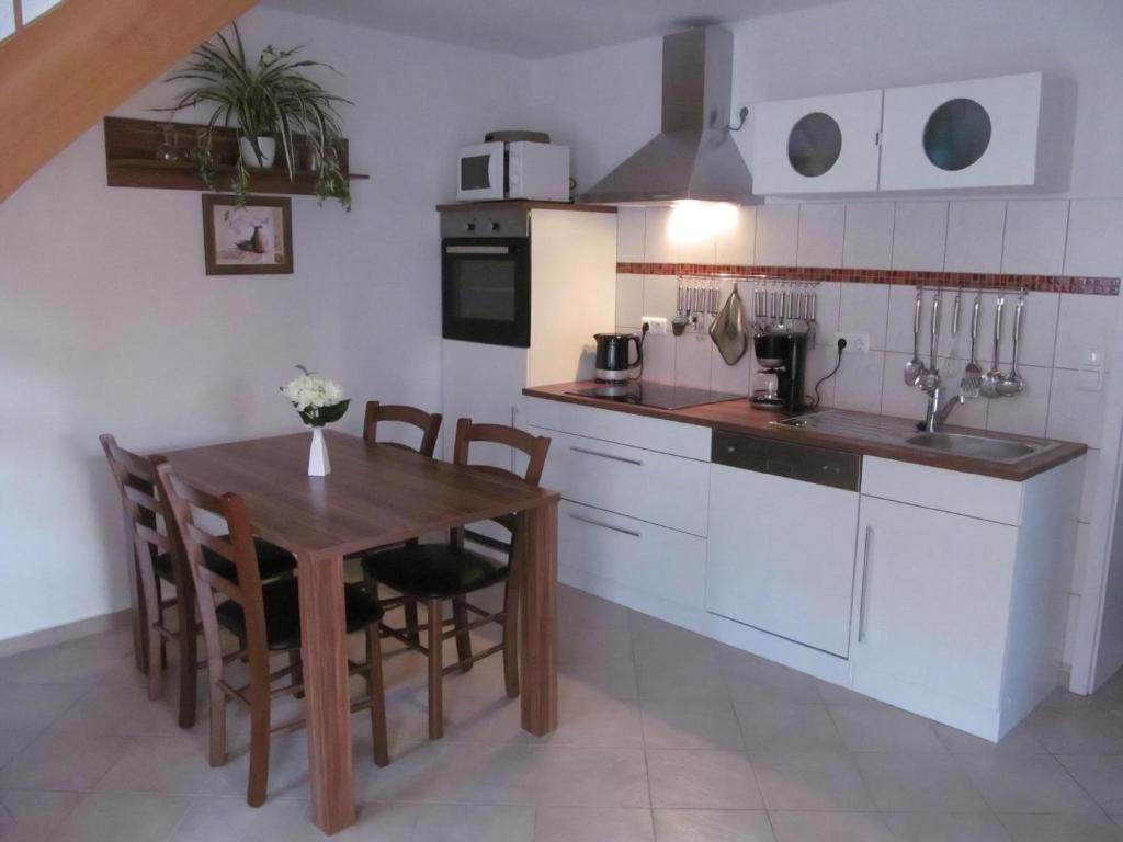 a kitchen with a wooden table and a dining room at Ferienhaus Uns Lütt Hüsung in Glambeck