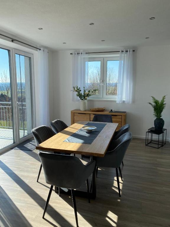 a dining room with a wooden table and chairs at FeWo Günztalblick - Ruhige Lage -125 qm - neu und komfortabel - große Terrasse in Frickenhausen