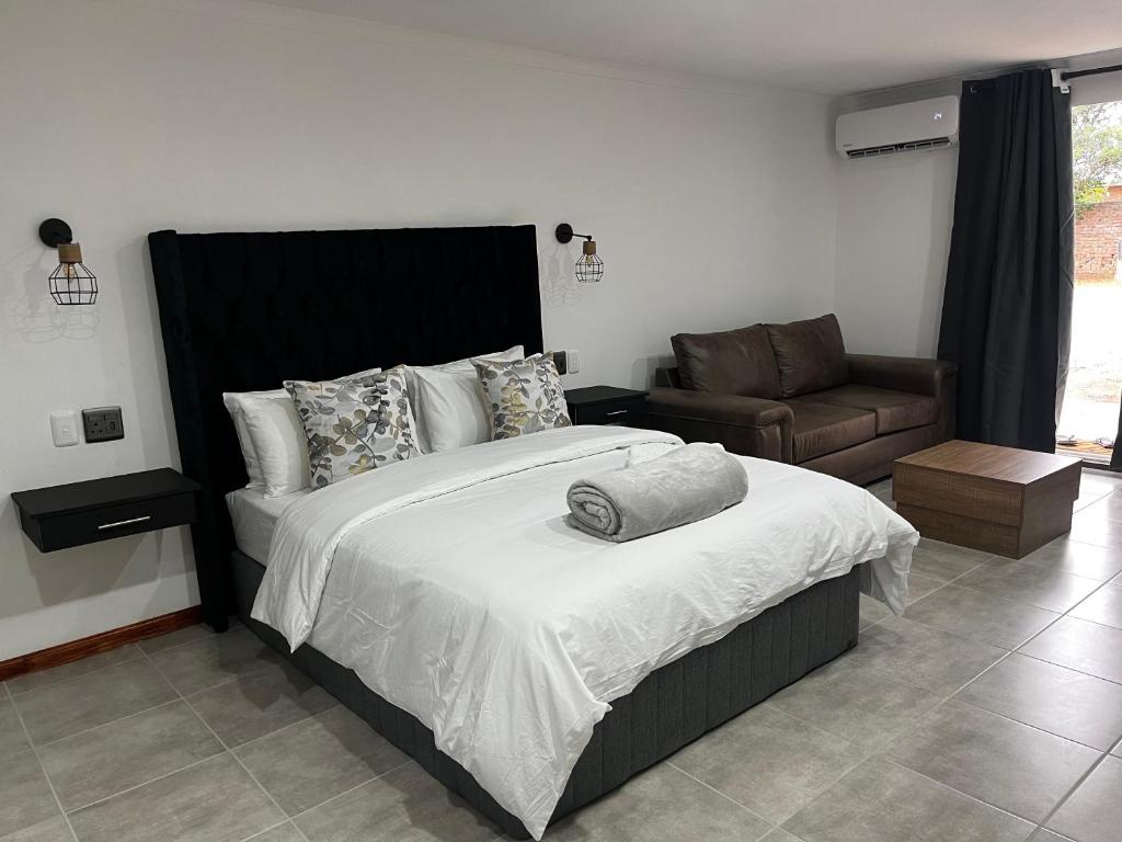 a bedroom with a large bed and a couch at Riverstone Studio - Self Catering in Cradock