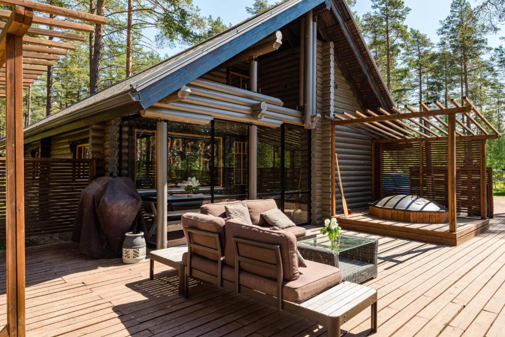 a house with a deck with a couch on a porch at Yyteri Beach Lomakeskus, Havulinna 26 in Pori