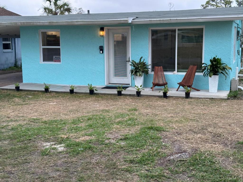 a blue house with two chairs on the porch at Castaway on Treasure Island NPR in New Port Richey