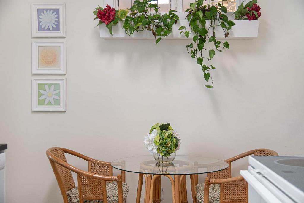 Una mesa con sillas y un jarrón de flores encima. en Private Hot Tub & Dundee Charm Close to Attractions, en Omaha