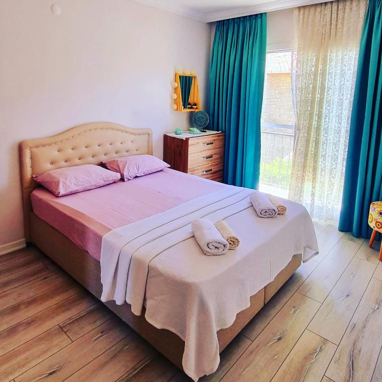 a bedroom with a bed with two towels on it at Egem House in Datca
