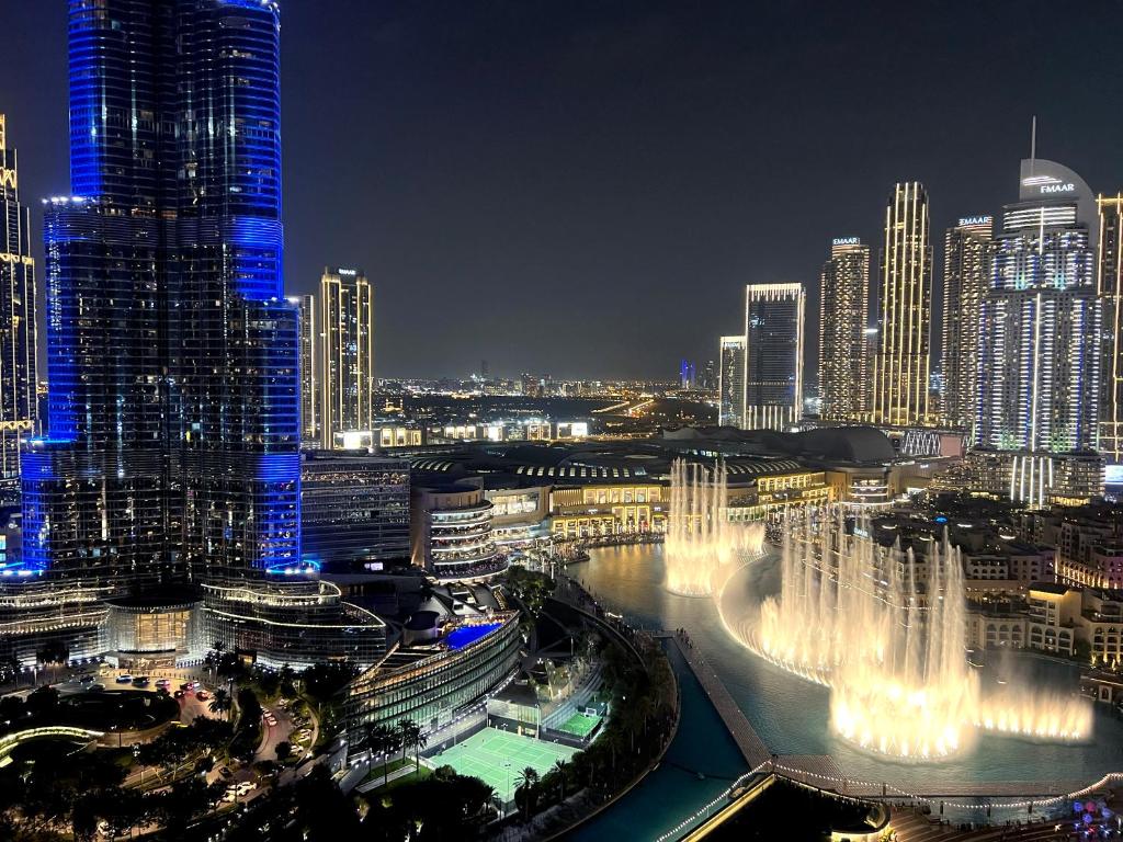 Hotel Downtown Luxury - Stunning Burj Khalifa & Fountain Views - 5 Minutes Walk to Dubai Mall, a view of a city at night with a fountain at Downtown Luxury - Stunning Burj Khalifa & Fountain Views - 5 Minutes Walk to Dubai Mall in Dubai