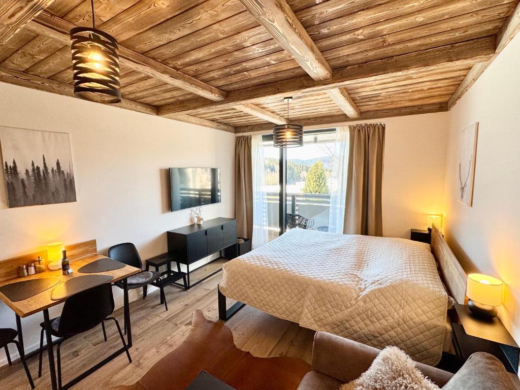 a bedroom with a bed and a table and chairs at CORSO RUSTIC Luxury Apartment Harrachov, Ski in - Ski out, Free Parking, High Speed Wi-fi, Smart TV in Harrachov