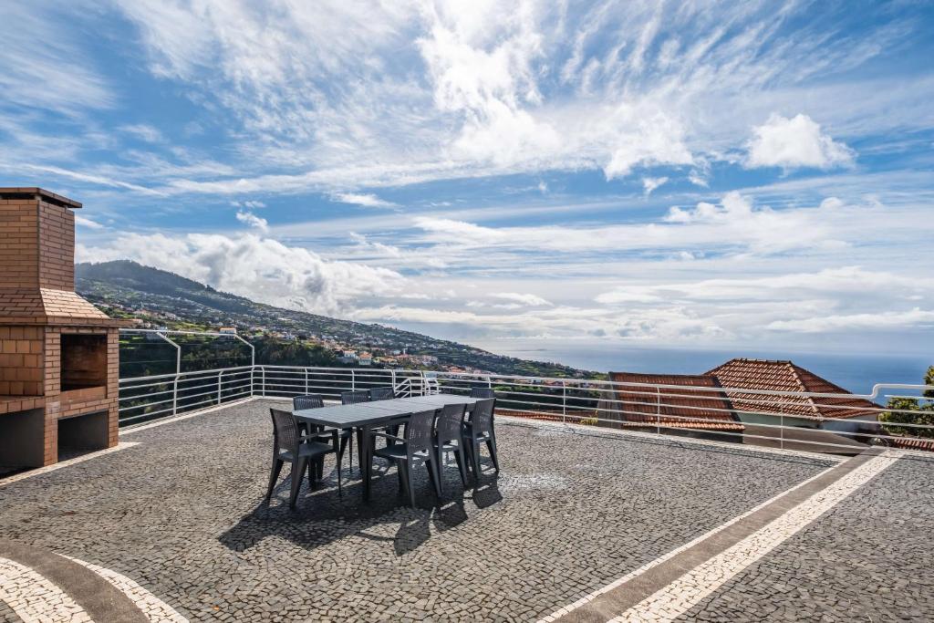 una mesa y sillas en la parte superior de un balcón en SunRise Vila, en Estreito da Calheta