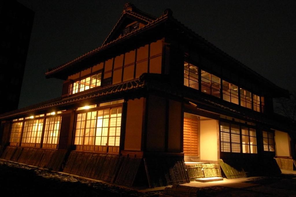 ein Gebäude mit beleuchteten Fenstern in der Nacht in der Unterkunft Hakusanjinjya Santokukan - Vacation STAY 18679 in Takasaki