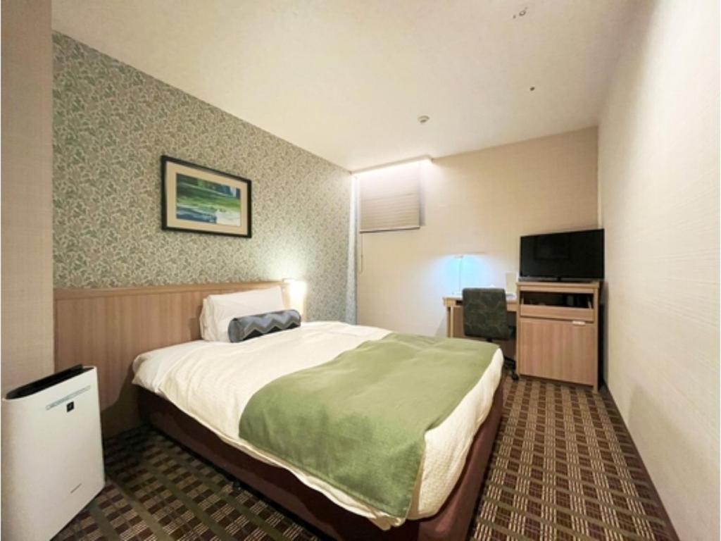 a hotel room with a bed and a television at Garden Hotel Shizuoka - Vacation STAY 45845v in Shizuoka