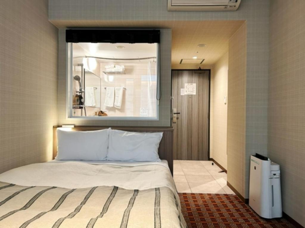 - une chambre avec un lit et une fenêtre au-dessus dans l'établissement Garden Hotel Shizuoka - Vacation STAY 45848v, à Shizuoka