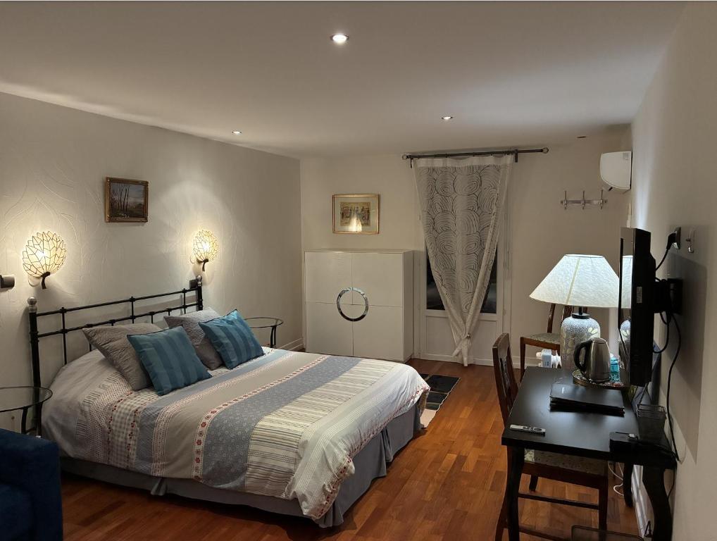 a bedroom with a bed and a table and a desk at Villa atmosphère PETIT DEJEUNER COMPRIS in Grenoble