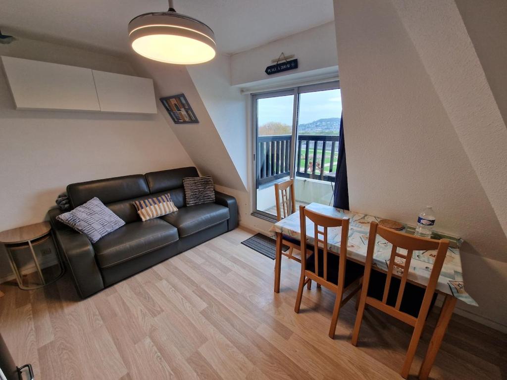 - un salon avec un canapé, une table et une salle à manger dans l'établissement Le Cocon Du Lac Villers Sur Mer, à Villers-sur-Mer