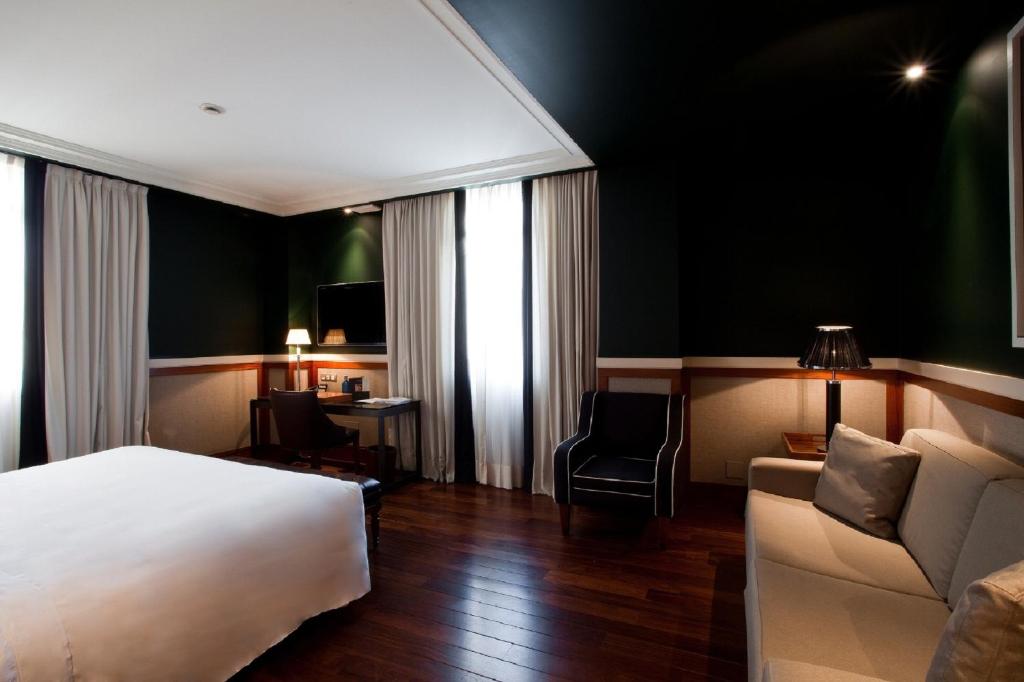 a hotel room with a bed and a couch at Hotel 1898 in Barcelona